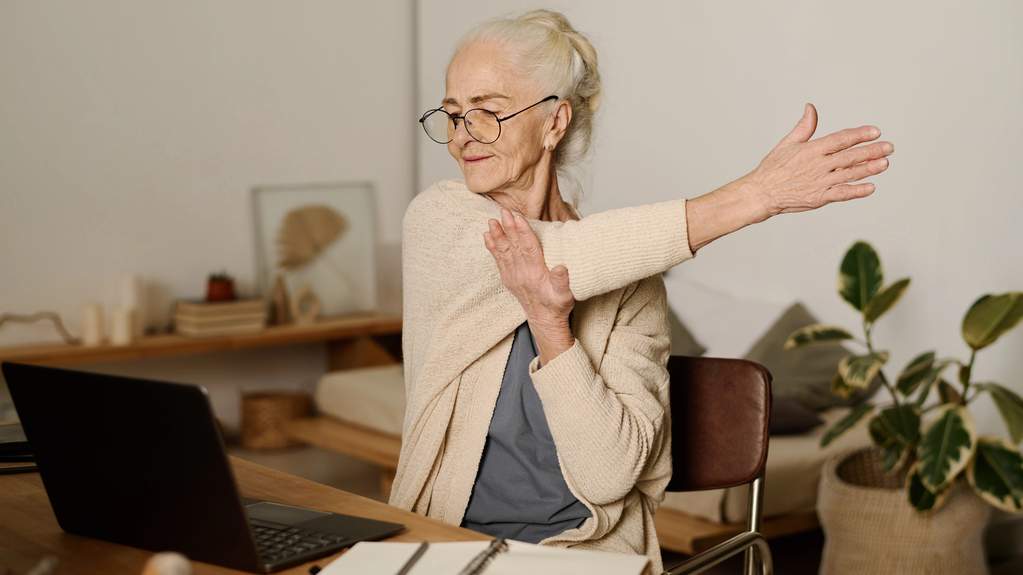 Person sitting still at a desk, legs visible from the knee down in a quiet indoor setting