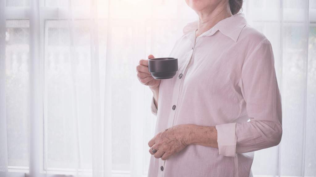 Woman walking away from her desk in a bright home office during a movement break