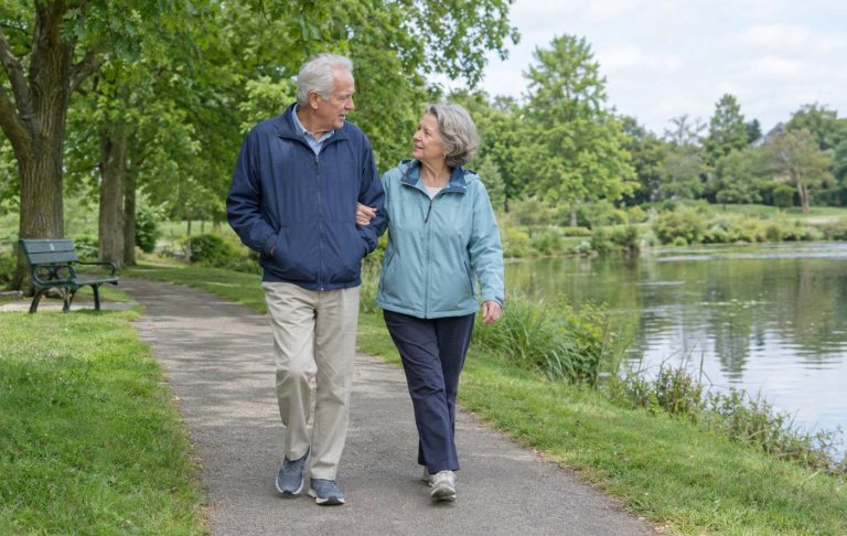 A couple in their seventies walking together through a park